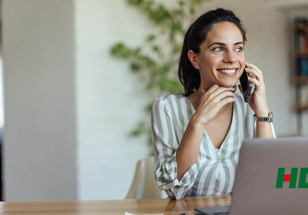 Frau am Telefon mit HDI Logo